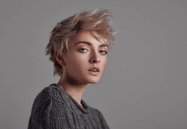 Sarışın kısa saçlı gri arka plan üzerinde izole kadın portresi