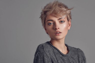 Sarışın kısa saçlı gri arka plan üzerinde izole kadın portresi