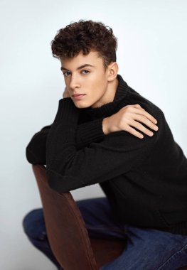 Oturma ve kameraya bakarak yakışıklı adam