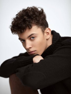 Oturma ve kameraya bakarak yakışıklı adam