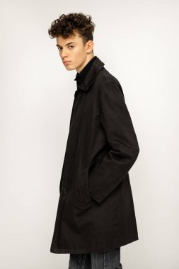 Siyah uzun palto giymiş yakışıklı genç 