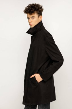 Siyah uzun palto giymiş yakışıklı genç 