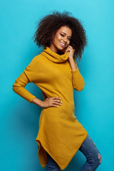 Beautiful african american woman with afro wearing cardigan and looking at camera