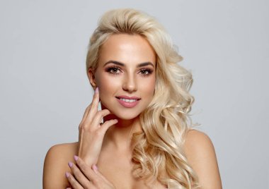 Yanağı gri arka plan üzerinde izole dokunmadan sarışın bautiful kadın