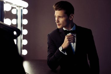 Dolap aynaya bakarak siyah elbiseli seksi adam