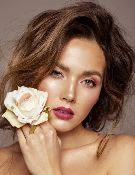 Close up face of young girl with rose in hand touching cheek — Stock Photo, Image