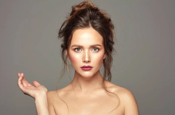 Young woman with opened hand looking at camera isolated — Stock Photo, Image