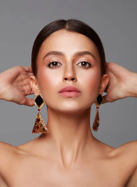 Close-up gezicht van jonge vrouwelijke model dragen oorbellen — Stockfoto