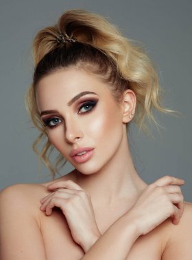 Elleri dekolte üzerinde olan, bağlı saçlı yakın çekim model yüz