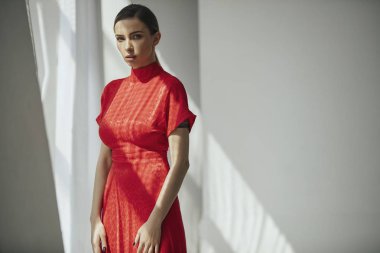 Gri arka planda poz kırmızı elbise baştan çıkarıcı sarışın kadın Portresi 