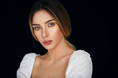 Baştan çıkarıcı sarışın kadın portresi siyah arka plan üzerinde kameraya bakarak 