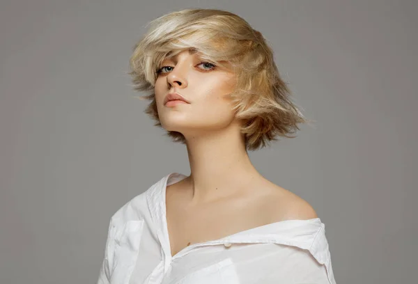 Portrait of blonde woman with short hair wearing white shirt