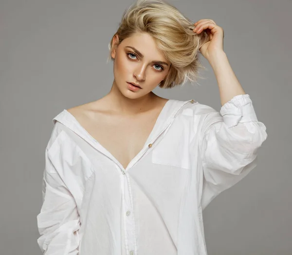 Portrait of blonde woman with short hair wearing white shirt