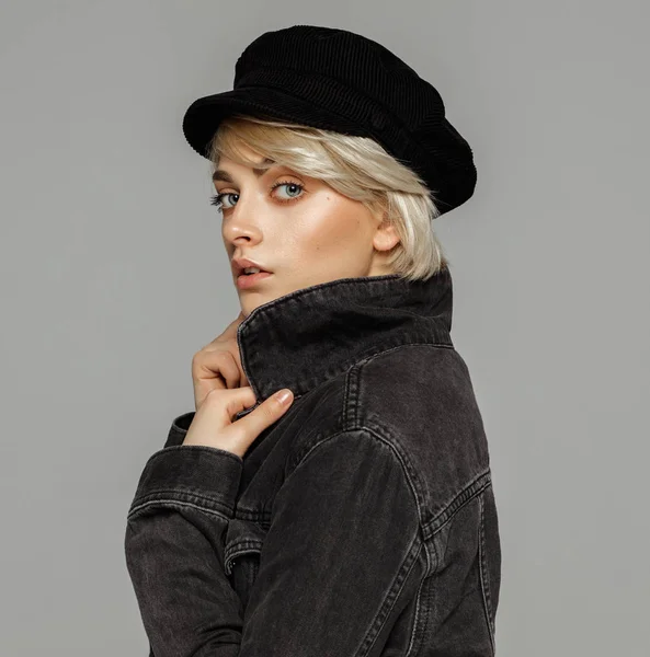 年轻金发女郎在黑色牛仔夹克和帽子的时尚肖像 — 图库照片