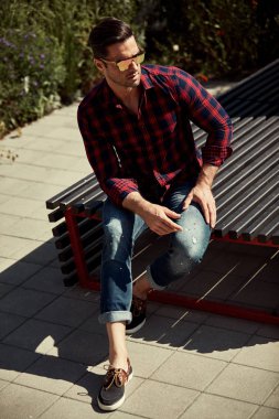 Ekose gömlek ve kot kentsel arka planda poz genç yakışıklı adam