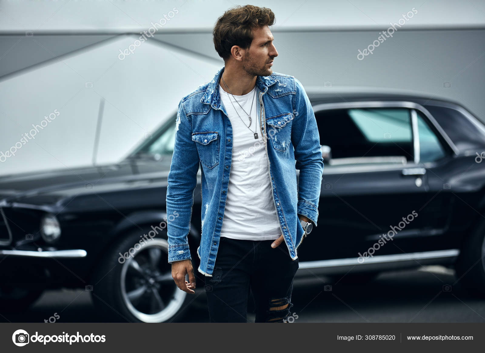 Glamour Attractive Young Man in Fashionable Denim Jacket in Vintage T-shirt  in Trendy Jeans Enjoys Relaxing Outdoors. Handsome Stock Photo - Image of  model, cool: 238542852