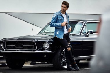 Siyah klasik araba ile poz denim ceket yakışıklı adam