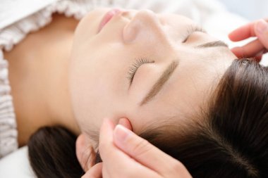 Akupunkturda shiatsu alan bir kadın.