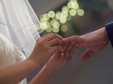 Japon gelin ve damadın elleri yüzükleri değiş tokuş ediyor.