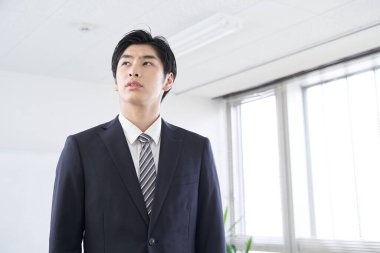 Japon erkek işadamı konferans odasında düşünüyor.