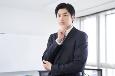 Japon erkek işadamı konferans odasında düşünüyor.