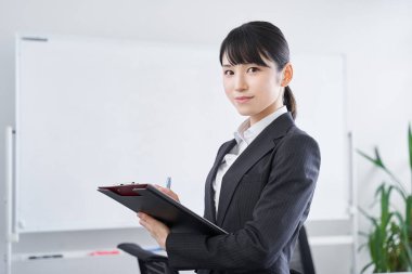 Japon bir kadın iş kadını ofisinde bir duruşma düzenliyor.