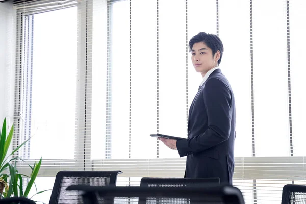 Japansk Affärsman Som Håller Surfplatta Kontorsfönstret — Stockfoto