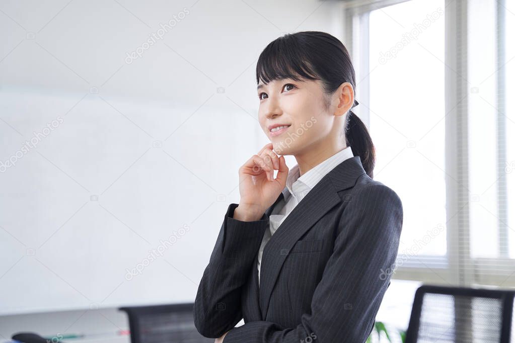 A Japanese woman in her office thinking