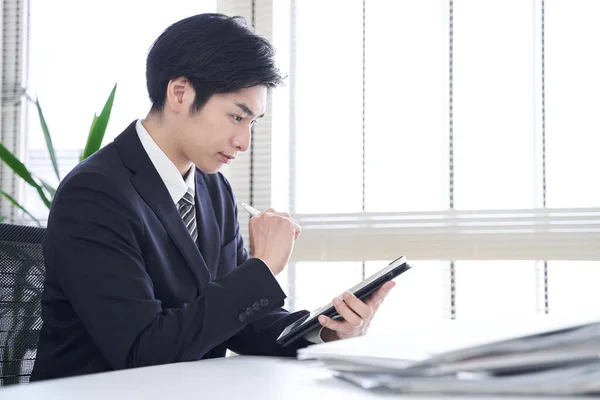 Egy Japán Férfi Üzletember Táblagépet Használ Irodájában Hogy Papíralapú Dokumentumokat — Stock Fotó