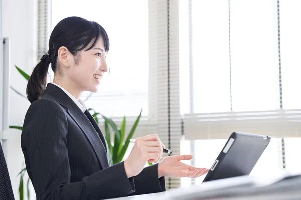 日本の女性実業家は インタビューのためにオフィスでタブレットを使用しています — ストック写真