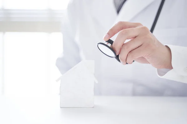 Image of diagnosing real estate in a doctor\'s outfit.