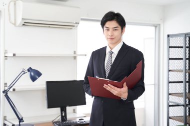 Japon bir erkek emlakçı ev gösteriyor.