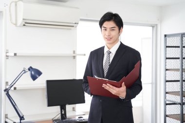 Japon bir erkek emlakçı ev gösteriyor.