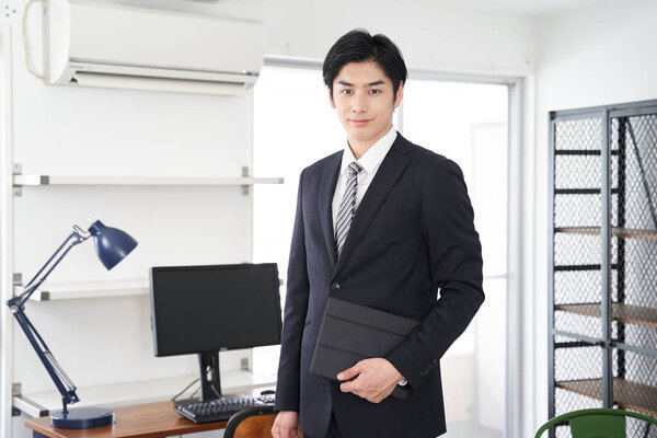 A Japanese male real estate salesman showing a house