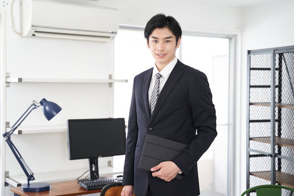 A Japanese male real estate salesman showing a house