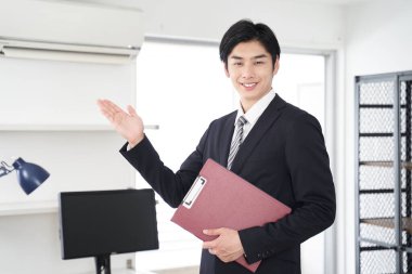 Japon bir erkek emlakçı ev gösteriyor.