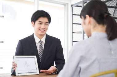 Japon bir emlak satıcısı odayı açıklamak için tablet kullanıyor.