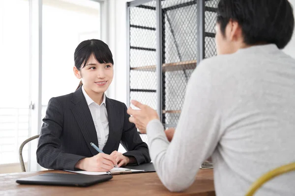 一位日本女性房地产销售员倾听顾客的要求 — 图库照片