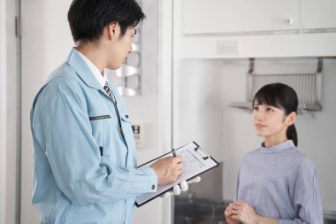 Odada ekipman sorunu yaşayan bir Japon erkek işçi.