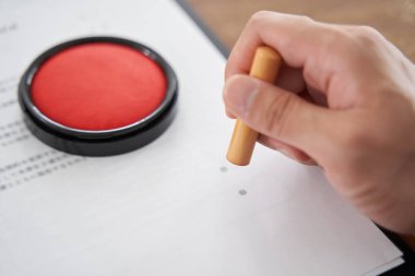 Kişisel mührünü belgelere basan bir Japon erkek işadamı (Japonca bir inşaat sözleşmesi olarak yazılmış bir belge))