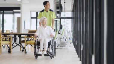Elderly people and caregivers walking in wheelchairs