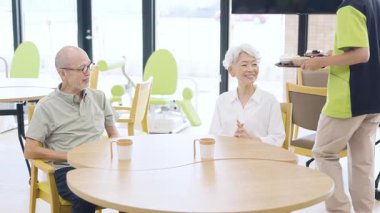 Elderly people waiting for meals at a nursing home