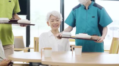 Elderly people waiting for meals at a nursing home