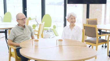 Elderly people sitting in the day room of a nursing home