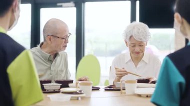 Asian elderly people eating at a nursing home