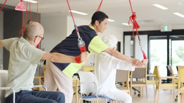 Elderly people receiving sling therapy at a nursing home
