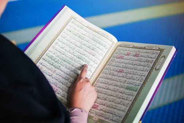 Närbild av muslimsk kvinna som läser den heliga Al Koranen inuti en moské — Stockfoto