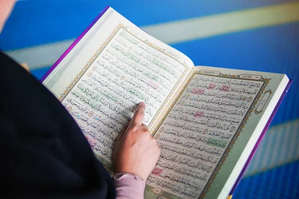 Närbild av muslimsk kvinna som läser den heliga Al Koranen inuti en moské — Stockfoto