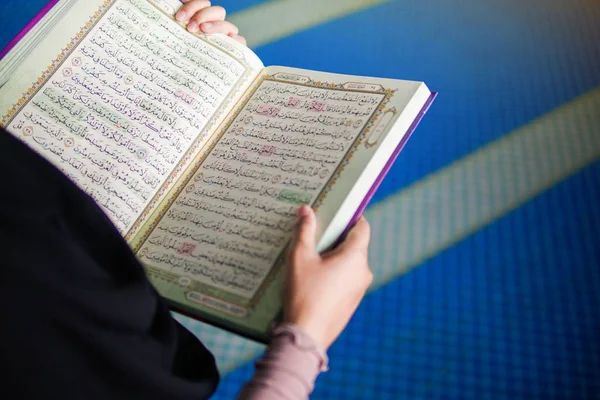 モスク内の聖なるアル・コーランを読むイスラム教徒の女性のクローズアップビュー — ストック写真