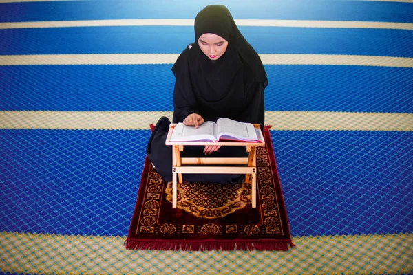 Giovane donna musulmana che recita Al Corano all'interno di una moschea. Al Corano è un Libro Sacro Islamico — Foto Stock
